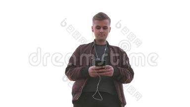 年轻的帅哥拿着手机听音乐。 基本观点
